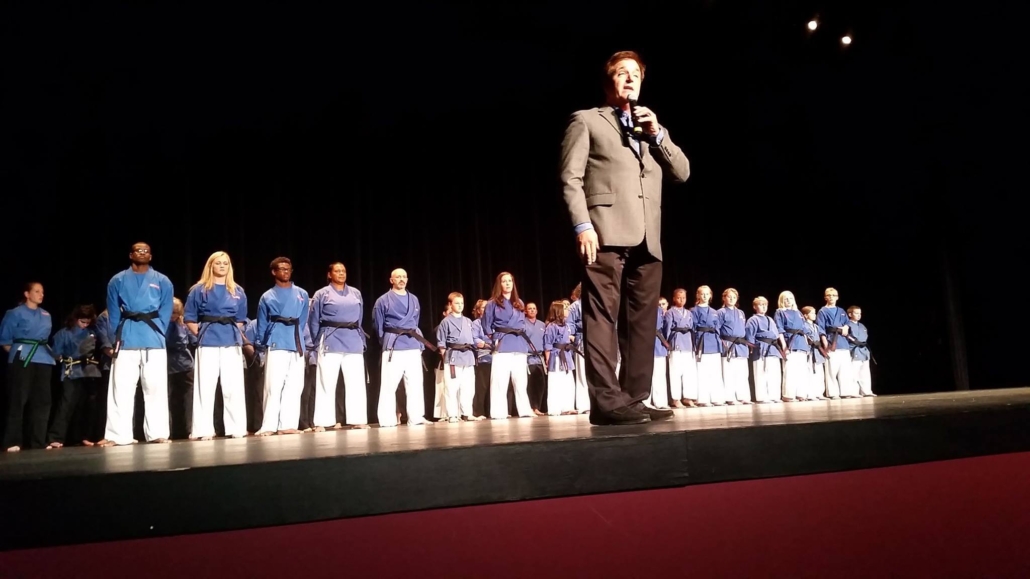 Grand Master Stephen Oliver on stage at a black belt graduation