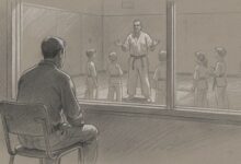 A parent watching a children's martial arts class through the studio window
