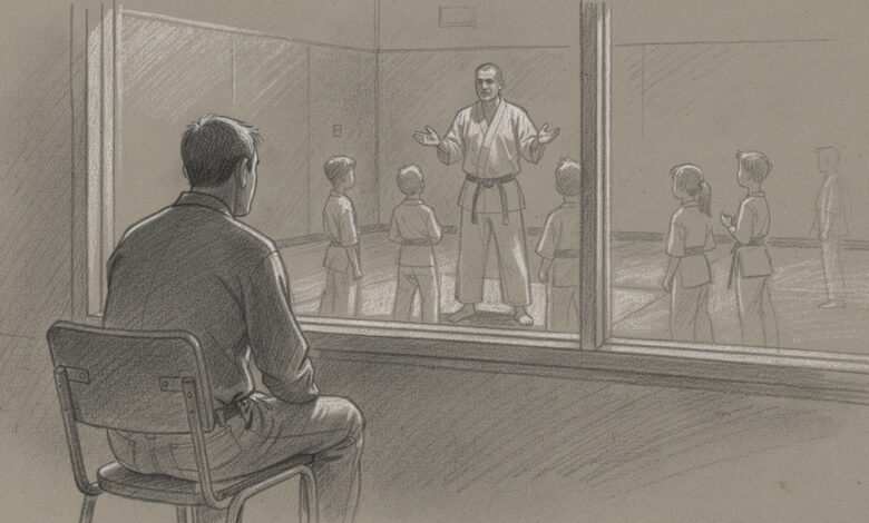 A parent watching a children's martial arts class through the studio window