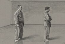 Two instructors standing apart in an empty training hall, not speaking