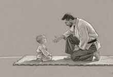 An instructor kneeling on the mat and reaching out a hand to a very young student sitting at eye level