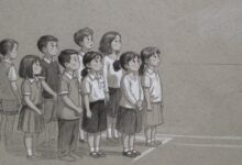 A group of children standing together watching something off to one side, none of them moving