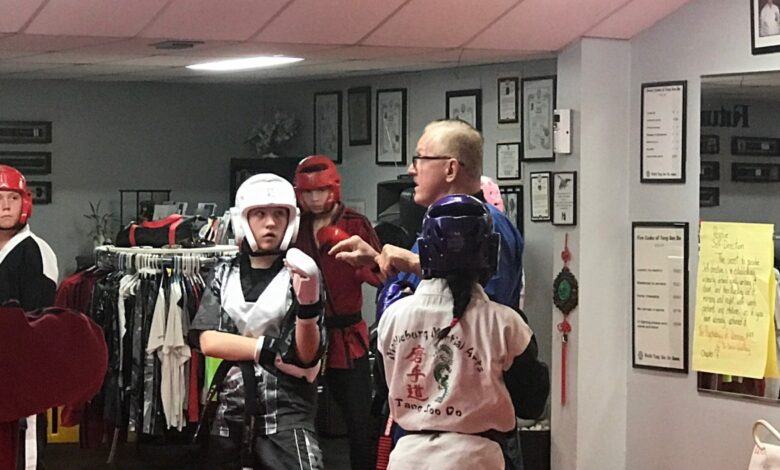 Grand Master Jeff Smith coaching students through sparring drills in headgear