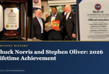 Chuck Norris black belt in its case, Keith Yates presenting books, and Stephen Oliver induction certificate