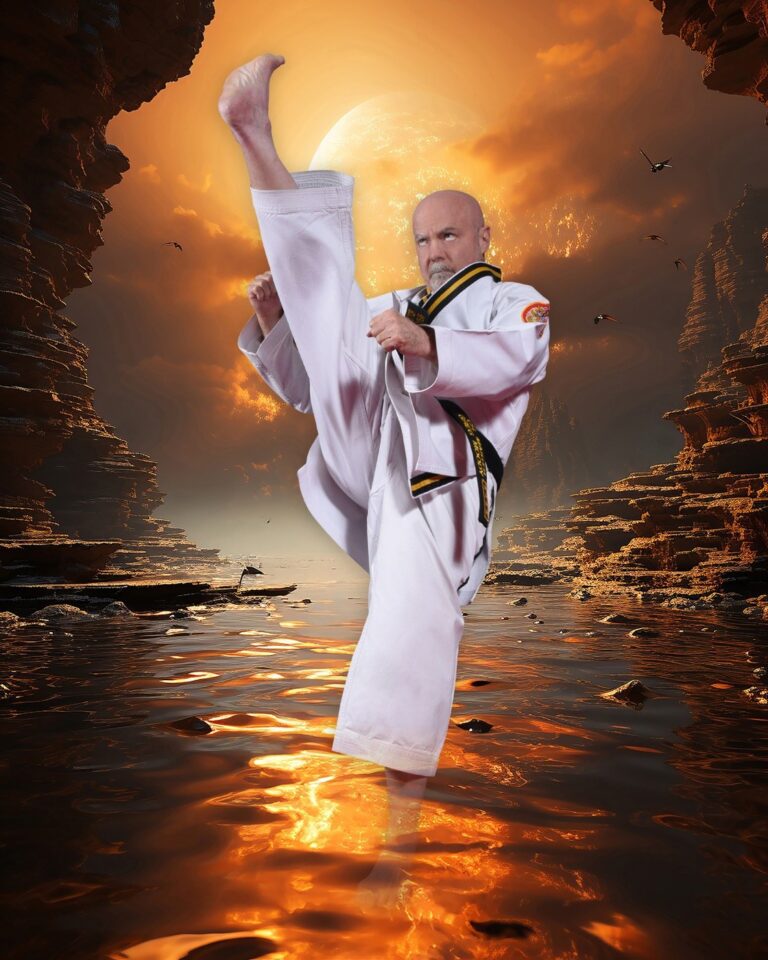 Chief Master Greg Moody in a white uniform throwing a high side kick